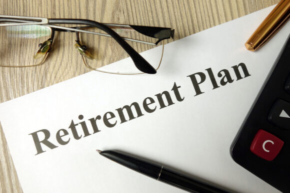 Paper on a desk with the words "retirement plan" printed on it.