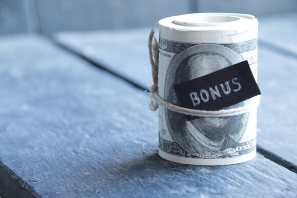 The word bonus tucked into a roll of money.