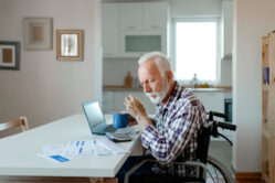 Veteran sitting in wheelchair at table going through financial documents